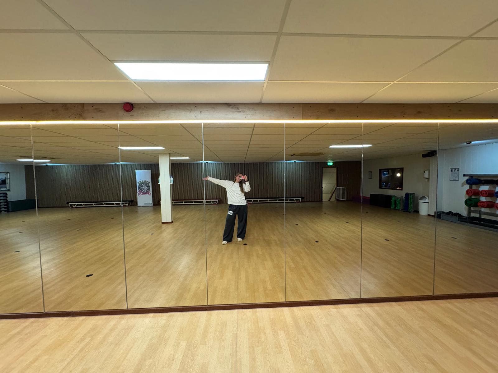 De danszaal van Streetbeatz met spiegelwand en houten vloer